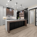 Light gray and black painted kitchen cabinets with walnut accent hutch cabinets, with a pullout walnut table connected to the island.