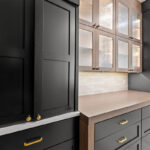 Black cabinetry surrounding a stained walnut accent hutch cabinet.