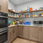 Light stained prep kitchen cabinets on stone wall.