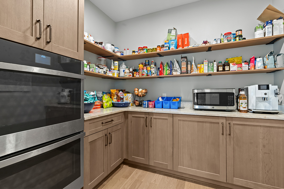 Light stained prep kitchen cabinets on stone wall.