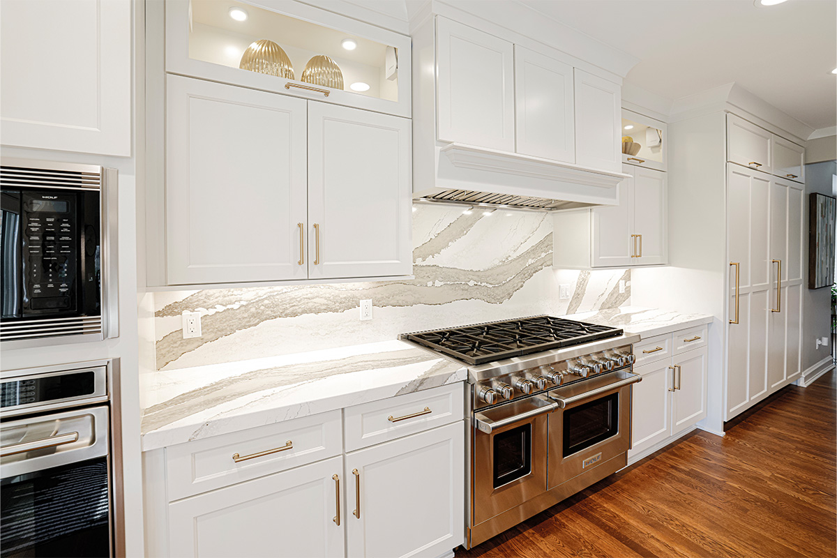 White kitchen cabinets showing hood and stove.