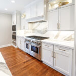 White kitchen cabinets showing hood and stove.