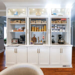 Open pocket door cabinets showing appliances and items inside.