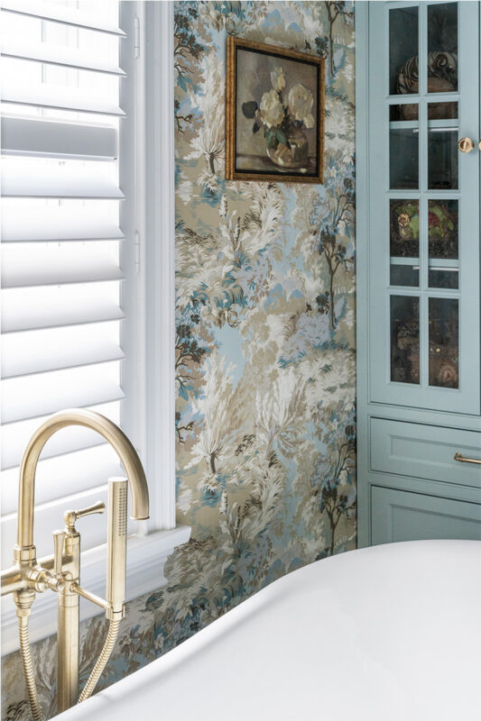 Light blue bathroom cabinet with flowered wall paper.