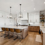 White painted and light brown stained kitchen with island.