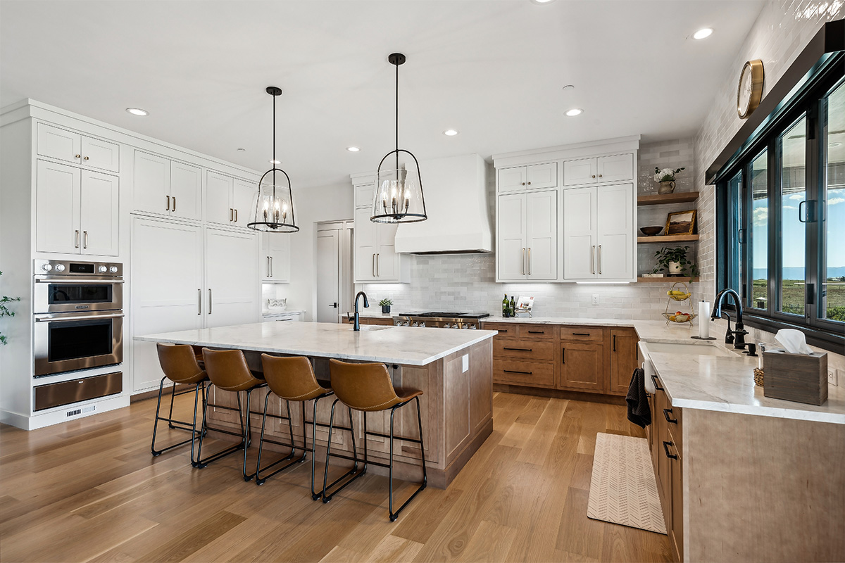 White painted and light brown stained kitchen with island.