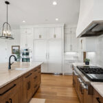 White painted and light brown stained kitchen with island.