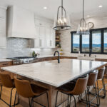 White painted and light brown stained kitchen with island.