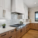 White painted and light brown stained kitchen with island.