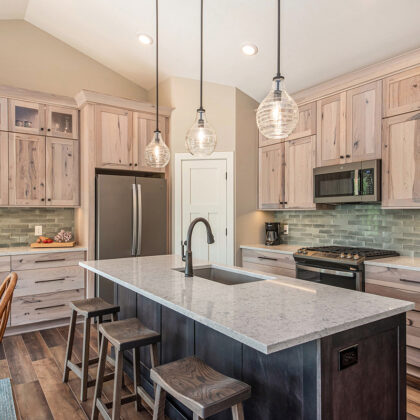 Light stain on perimeter kitchen cabinets and dark stain on island.
