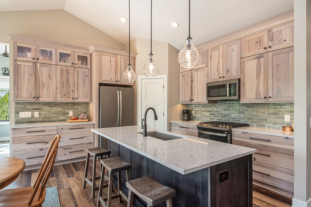 Light stain on perimeter kitchen cabinets and dark stain on island.