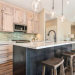 Light stain on perimeter kitchen cabinets and dark stain on island.