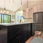 Light stain on perimeter kitchen cabinets and dark stain on island.