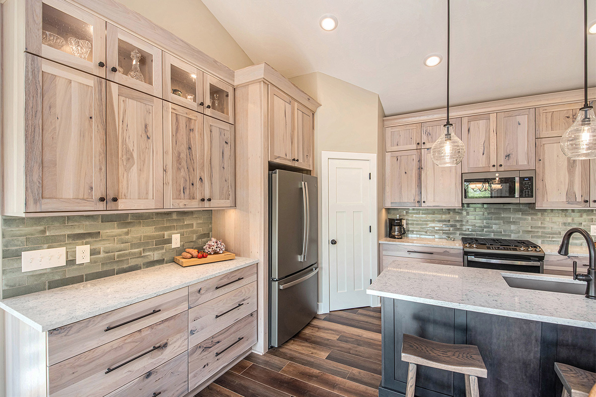 Light stain on perimeter kitchen cabinets and dark stain on island.