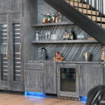 Dark stained hickory bar cabinets under a staircase