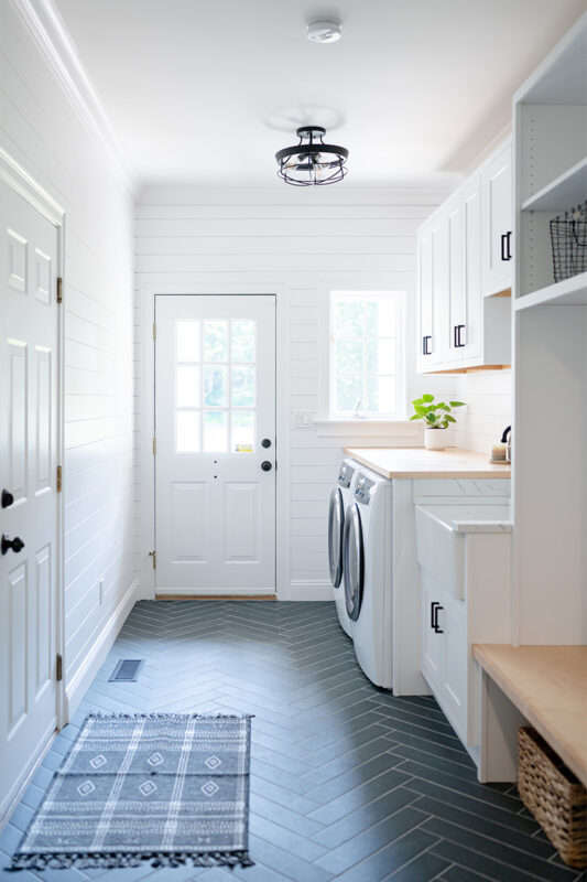 Painted white laundry/mud room with lockers.