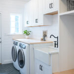 Painted white laundry/mud room with lockers.