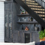 Dark stained hickory bar cabinets under a staircase