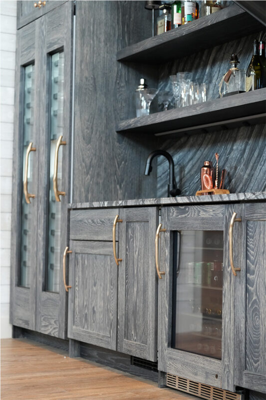 Dark stained hickory bar cabinets under a staircase