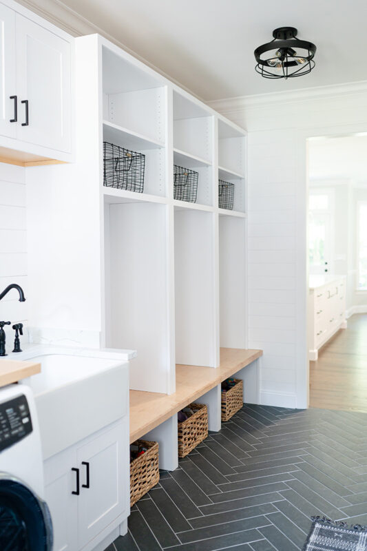 Painted white laundry/mud room with lockers.
