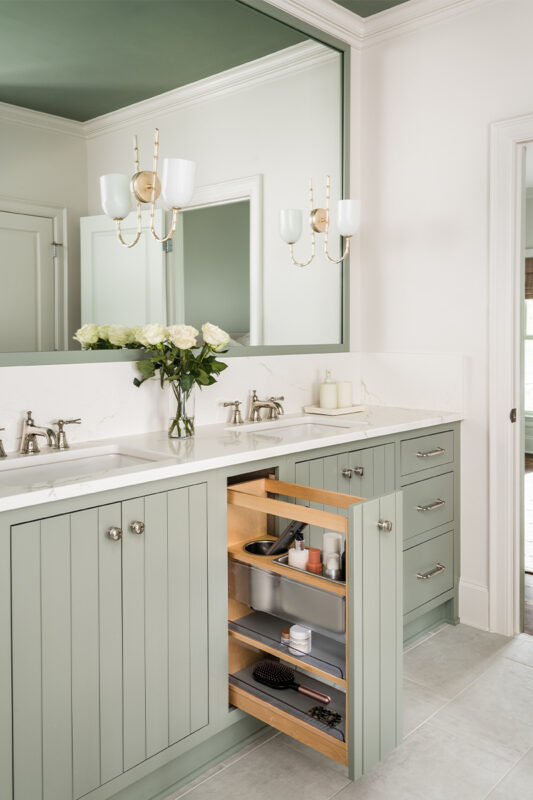 Light green painted bathroom vanity with pullout storage.