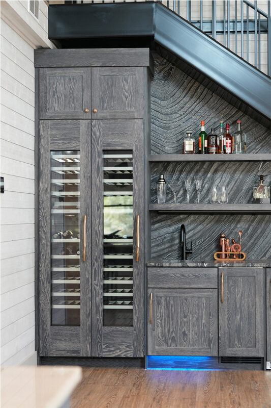 Dark stained hickory bar cabinets under a staircase