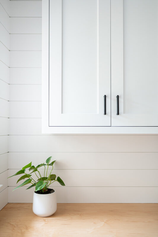 Painted white laundry/mud room with lockers.