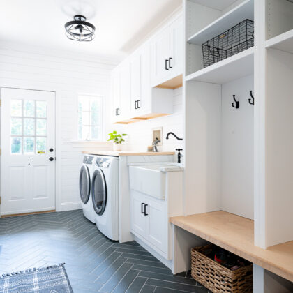 Painted white laundry/mud room with lockers.