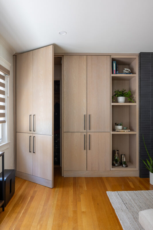 Dark brick fireplace with TV above and light stained cabinets on both sides.