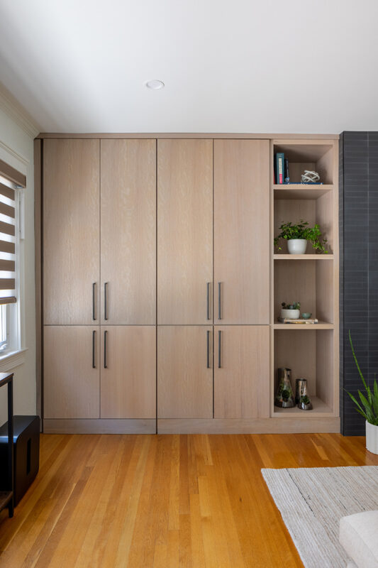 Dark brick fireplace with TV above and light stained cabinets on both sides.