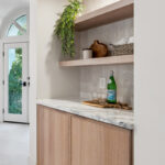 Light brown stained master bedroom cabinet with floating shelves.