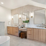 Double light brown bathroom vanities with powder desk in between.