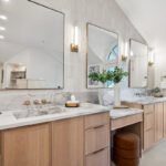 Double light brown bathroom vanities with powder desk in between.
