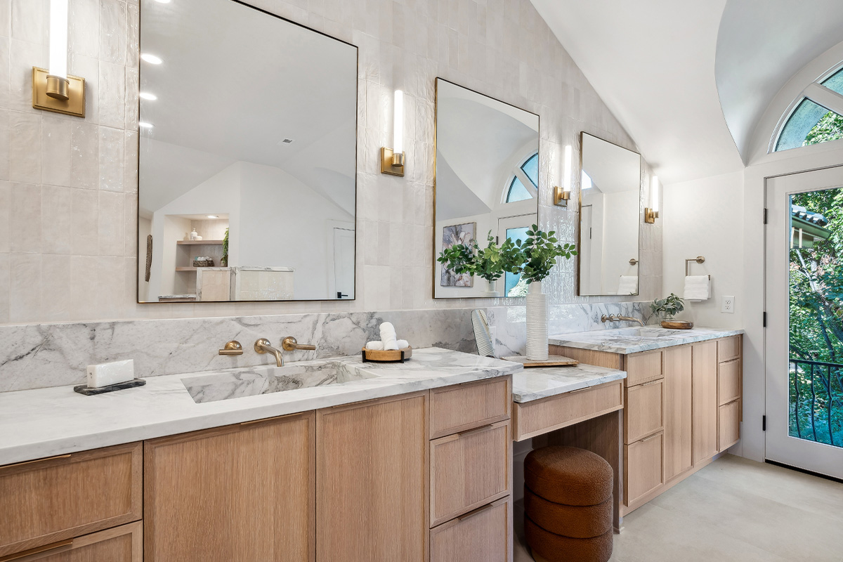 Double light brown bathroom vanities with powder desk in between.