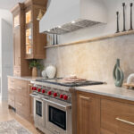 Stained white oak kitchen with a white hood.