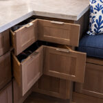 Brown-stained corner drawer cabinet with drawers pulled out.