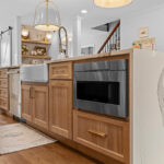 Brown stained kitchen cabinets with under counter microwave