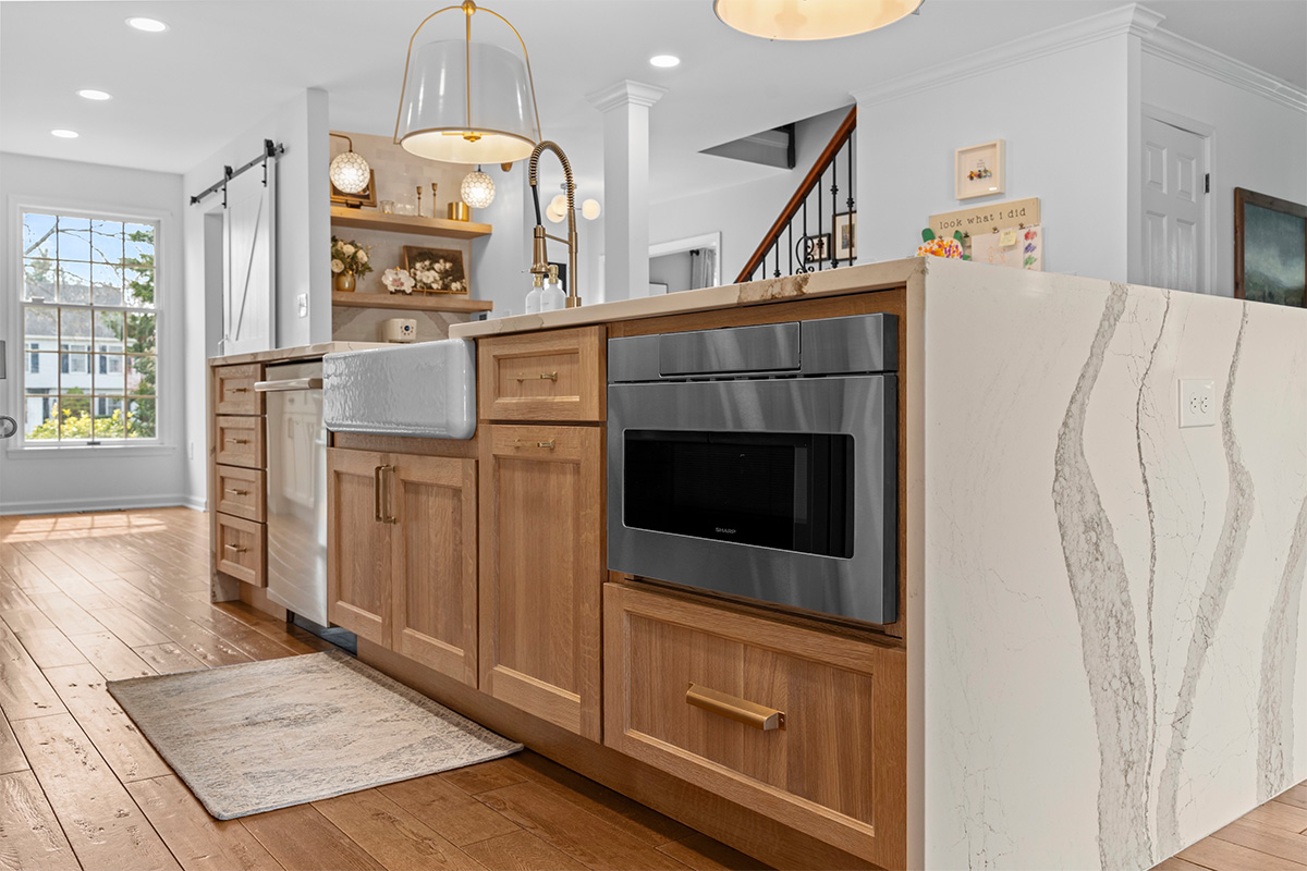 Brown stained kitchen cabinets with under counter microwave