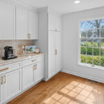 White kitchen cabinets near a large window