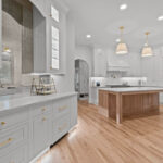 White kitchen perimeter cabinets with an island in washed out light brown Vita stain on Rift White Oak.