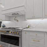White kitchen perimeter cabinets with stainless steel stove