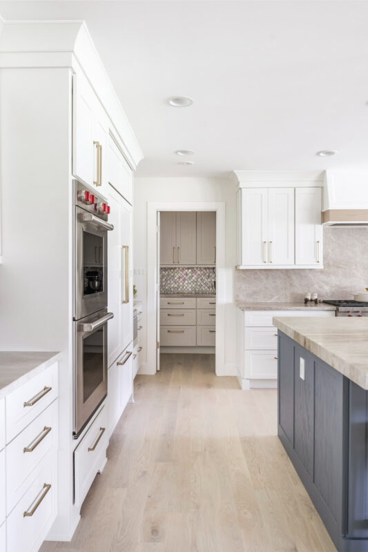 Kitchen with white perimeter and blue island cabinets.
