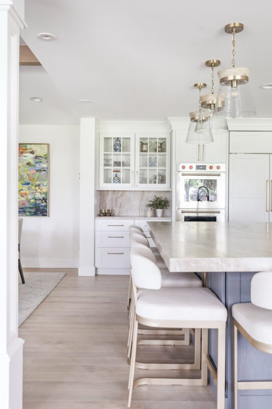 Kitchen with white perimeter and blue island cabinets.