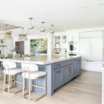Kitchen with white perimeter and blue island cabinets.