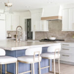 Kitchen with white perimeter and blue island cabinets.