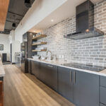 Gray painted office breakroom kitchen cooktop and metal hood.
