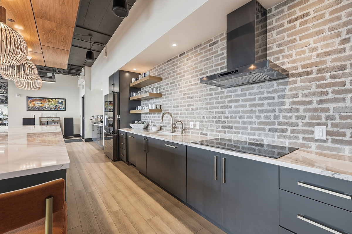 Gray painted office breakroom kitchen cooktop and metal hood.