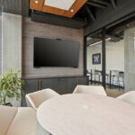 Conference room table and tv above gray cabinets.