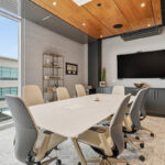 Conference room table and tv above gray cabinets.