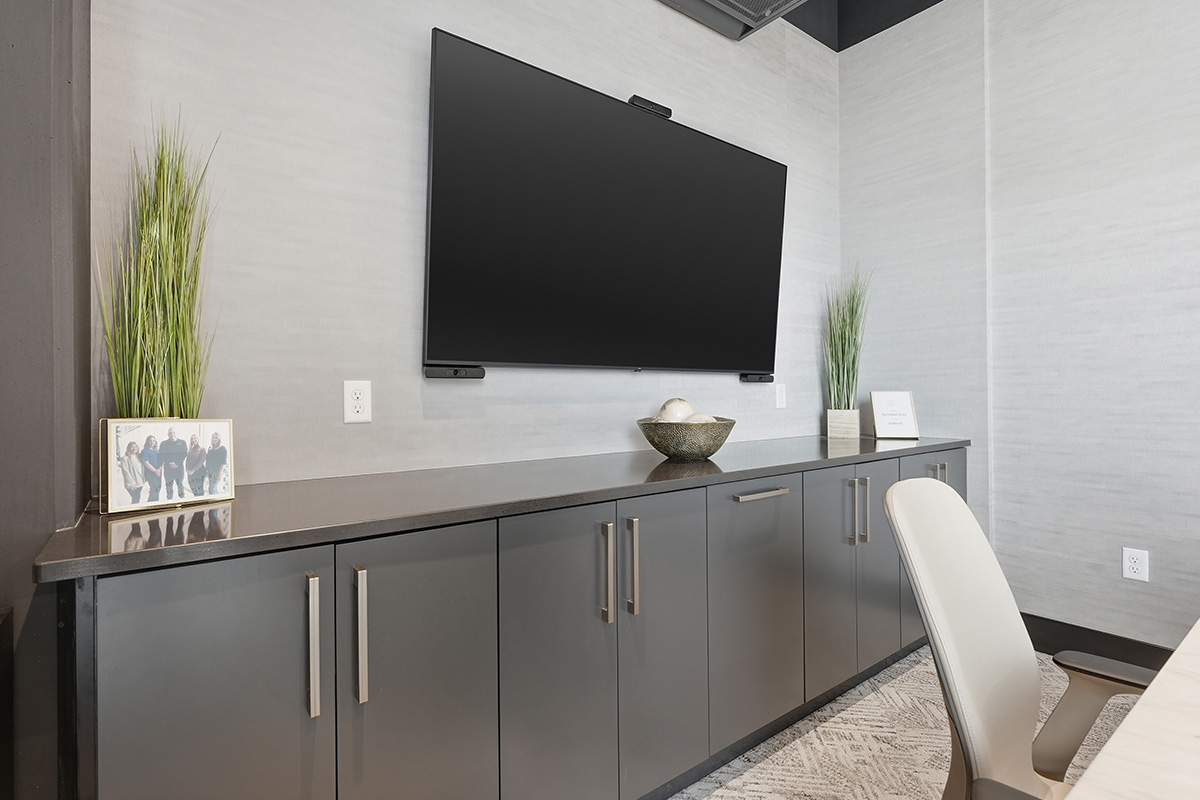 Conference room tv above gray cabinets.